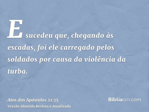 E sucedeu que, chegando às escadas, foi ele carregado pelos soldados por causa da violência da turba.